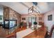 Dining room features a stone fireplace, modern lighting, and backyard access at 7815 Armadillo Trl, Evergreen, CO 80439