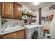 Well-equipped laundry room with updated washer and dryer, sink, and ample storage at 7815 Armadillo Trl, Evergreen, CO 80439