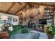 Cozy living room with a stone fireplace, wood ceiling, built-in bookshelves, and plush green seating at 7815 Armadillo Trl, Evergreen, CO 80439