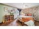 Bright main bedroom features wallpaper accent, built-in bookcase, and ceiling fan at 7815 Armadillo Trl, Evergreen, CO 80439