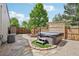 Backyard oasis featuring a hot tub, stone pathway, mature trees, and privacy fencing at 912 Oakwood Dr, Castle Rock, CO 80104