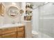 Modern bathroom with wood cabinets, round mirror and tiled glass shower at 912 Oakwood Dr, Castle Rock, CO 80104