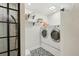 Bright laundry room with modern washer and dryer, decorative patterned floors, and shelving at 912 Oakwood Dr, Castle Rock, CO 80104