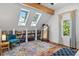 Attic space featuring wood floors, a blue chair, a colorful rug, and two skylights at 3170 W 29Th Ave, Denver, CO 80211