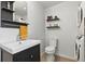 Bathroom featuring a modern vanity, toilet, shelves, and stacked washer and dryer at 3170 W 29Th Ave, Denver, CO 80211