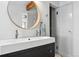 Modern bathroom with sleek vanity, round mirror, and glass-enclosed shower, offering a spa-like experience at 3170 W 29Th Ave, Denver, CO 80211