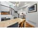 Open concept dining area with modern lighting, a wood table, and adjacent staircase and kitchen at 3170 W 29Th Ave, Denver, CO 80211