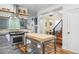 Bright kitchen featuring butcher block island, stainless steel appliances, and modern hood at 3170 W 29Th Ave, Denver, CO 80211