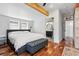 Spacious primary bedroom featuring wood floors, a beam ceiling, and an ensuite bathroom at 3170 W 29Th Ave, Denver, CO 80211