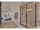 Ensuite bathroom featuring a tiled shower with a glass door, tile floors, and access to the bedroom at 16453 Homestead Ct, Parker, CO 80134