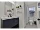 Modern bathroom featuring a navy vanity, white walls, and a shower with a curtain at 16453 Homestead Ct, Parker, CO 80134