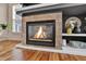 Close-up of a fireplace with a stone surround, complemented by built-in shelving and hardwood floors at 16453 Homestead Ct, Parker, CO 80134