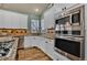 Bright kitchen featuring white cabinets, stainless steel appliances, granite countertops, and hardwood floors at 16453 Homestead Ct, Parker, CO 80134