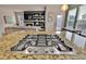 Granite countertop island with a cooktop and stainless steel appliances overlooking the living room at 16453 Homestead Ct, Parker, CO 80134