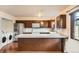 Functional kitchen featuring dark cabinets, stainless steel refrigerator, and granite island at 492 Vance St, Lakewood, CO 80226