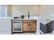 Wet bar area in basement with wooden cabinets, beverage cooler and countertop at 2475 W 69Th Pl, Denver, CO 80221