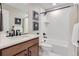 Bright bathroom with white subway tile, wooden vanity, and black fixtures at 2475 W 69Th Pl, Denver, CO 80221