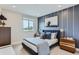 Comfortable bedroom with a blue accent wall, modern decor, and a large window at 2475 W 69Th Pl, Denver, CO 80221