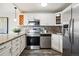 Updated kitchen with white cabinetry, stainless steel appliances, and a decorative tile backsplash at 909 N Logan St # 6K, Denver, CO 80203