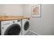 Modern laundry room with a front-load washer and dryer, complemented by stylish flooring at 21925 E 44Th Pl, Aurora, CO 80019