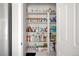 Pantry with ample shelving containing various pantry items next to a stainless steel refrigerator at 21925 E 44Th Pl, Aurora, CO 80019