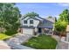 Charming two-story home with lush greenery, a spacious driveway, and well-maintained landscaping at 9147 W Rockland Pl, Littleton, CO 80128