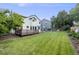 Well-maintained backyard with a large lawn, a wooden deck, and mature trees providing shade at 9147 W Rockland Pl, Littleton, CO 80128