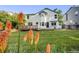 Landscaped backyard features a spacious lawn, a wooden deck, and colorful flowers adding to its charm at 9147 W Rockland Pl, Littleton, CO 80128