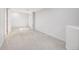 Clean basement featuring neutral carpet, white walls, and ample natural lighting at 9147 W Rockland Pl, Littleton, CO 80128