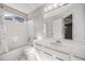 Clean bathroom featuring a bathtub, shower, white vanity, and large mirror at 9147 W Rockland Pl, Littleton, CO 80128