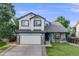 Charming two-story home with a manicured lawn, blue trim, and a spacious two-car garage at 9147 W Rockland Pl, Littleton, CO 80128
