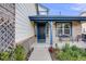 Inviting front porch with a seating area, adorned with colorful flowers and elegant exterior details at 9147 W Rockland Pl, Littleton, CO 80128