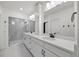 Elegant bathroom features double sinks, quartz countertop, white cabinets and glass-enclosed shower at 5037 N Quemoy St, Aurora, CO 80019