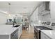 Elegant white kitchen with island, stainless steel appliances, and a seamless transition to the dining and living areas at 5037 N Quemoy St, Aurora, CO 80019