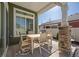 Covered patio features a neutral colored dining set and stone pillar at 5037 N Quemoy St, Aurora, CO 80019