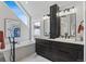 Bright bathroom with double vanity sinks, tub, and a large window offering natural light at 434 Clayton St, Denver, CO 80206