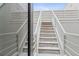 Exterior stairs with snowy wood steps leading up to an all white house at 434 Clayton St, Denver, CO 80206