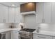 Modern kitchen featuring white cabinets, stainless steel appliances, and a decorative range hood at 434 Clayton St, Denver, CO 80206
