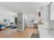 Open-concept kitchen and living room featuring modern appliances, white cabinetry, and hardwood floors at 434 Clayton St, Denver, CO 80206