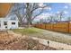 Spacious backyard featuring a lush lawn, mature trees, a charming garden path, and a storage shed at 2738 S Newton St, Denver, CO 80236