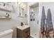 Bathroom with a glass-enclosed shower, modern sink, and built-in storage shelves for toiletries at 2738 S Newton St, Denver, CO 80236