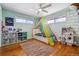 Bright bedroom with playful decor, hardwood floors, ample natural light from large windows at 2738 S Newton St, Denver, CO 80236