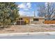 Quaint single-story home with brick accents and a yellow front door under a partly cloudy sky at 2738 S Newton St, Denver, CO 80236