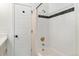 Bright bathroom featuring a bathtub with white tile surround and black accent tile at 2930 W 34Th Ave, Denver, CO 80211