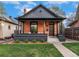 Charming brick home with a covered front porch, dark trim, and beautifully manicured lawn at 2930 W 34Th Ave, Denver, CO 80211