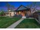 Charming brick home with a covered front porch, dark trim, and beautifully manicured lawn at 2930 W 34Th Ave, Denver, CO 80211