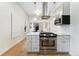 Modern kitchen with stainless steel appliances, white cabinets, light hardwood floors and contemporary lighting at 2930 W 34Th Ave, Denver, CO 80211
