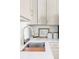 Close up of the kitchen sink showcasing gold fixtures, bright white countertops, and white subway tile backsplash at 2930 W 34Th Ave, Denver, CO 80211