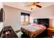 Functional bedroom featuring a bed, side table, window, television, and storage at 17085 E Dorado Cir, Centennial, CO 80015