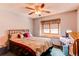 Bright bedroom featuring a ceiling fan, large window, wood trim, and queen sized bed at 17085 E Dorado Cir, Centennial, CO 80015